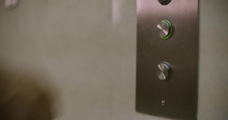 A person presses an elevator call button