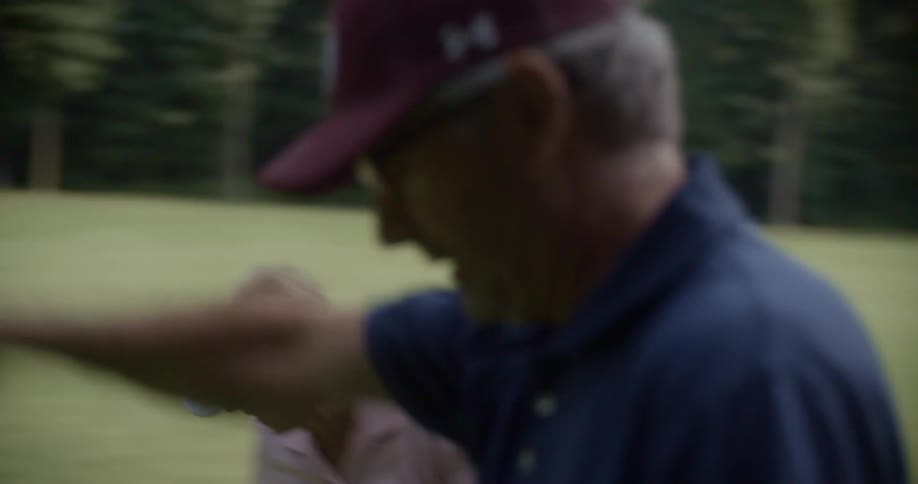 A man high fives his partner on the golf course during the day