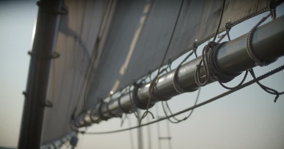 The sails of a boat rock back and forth in the wind