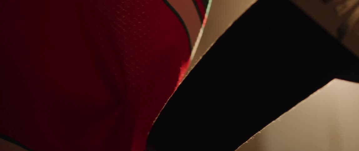 A hockey player wrapping tape around a hockey stick