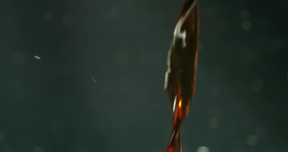 A brown liquid being poured out quickly