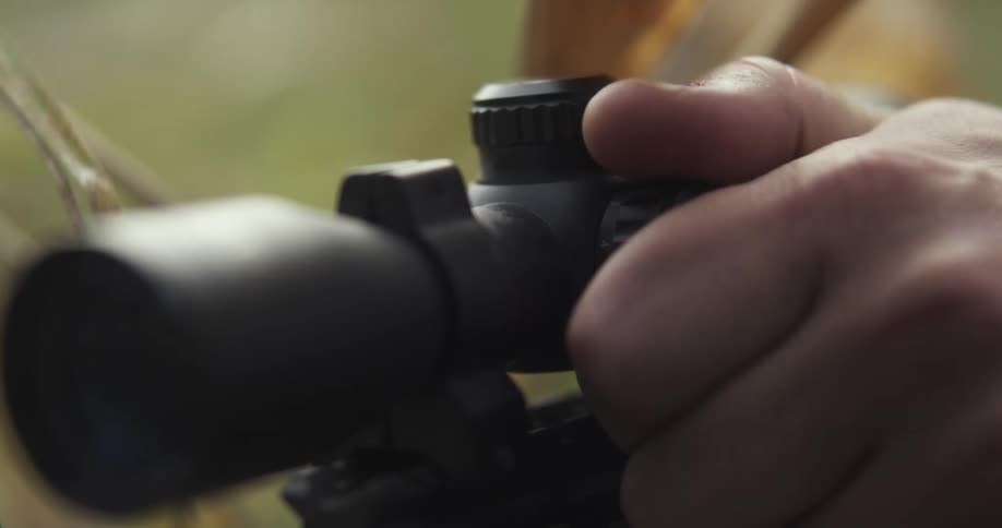 A man adjusts a knob on a gun