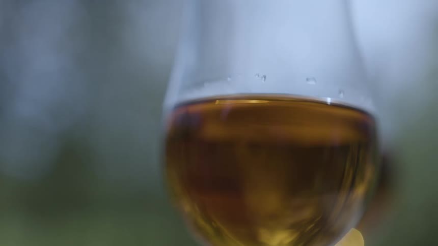 Clear golden colored liquid jiggles in the wine glass