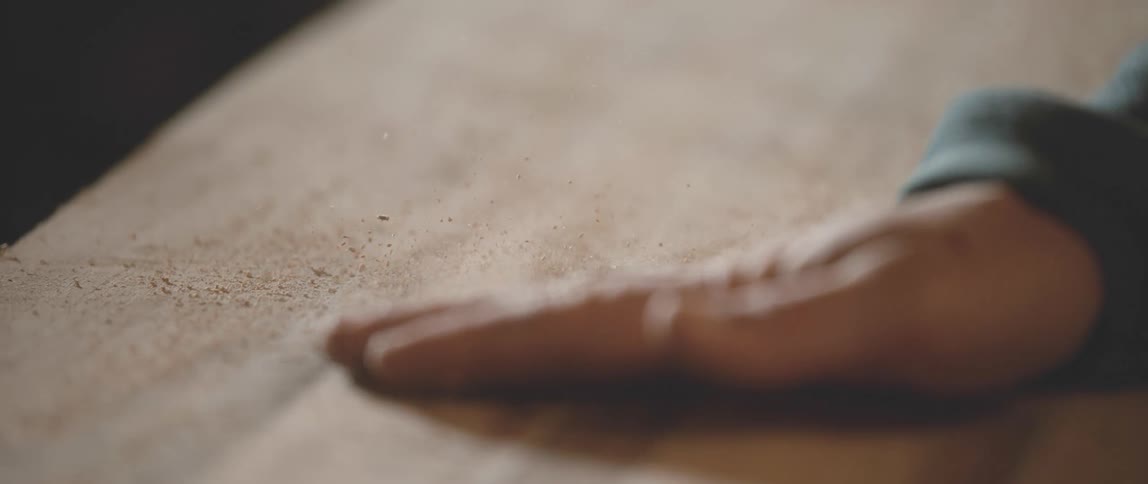 A person rubbing a piece of wood