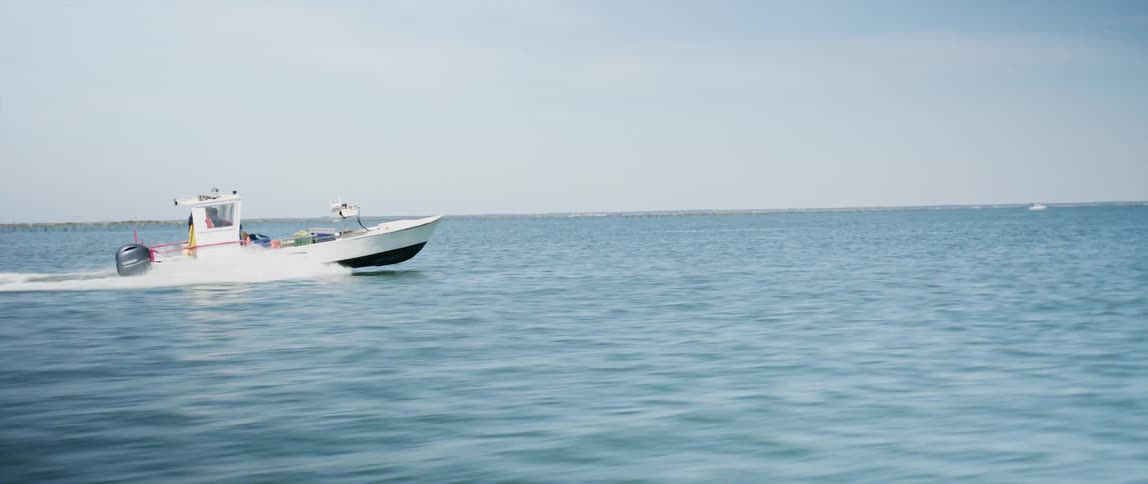 A speedboat speeds through the open seas