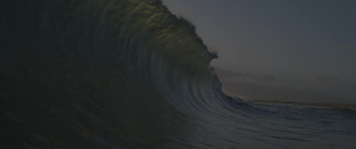 A tall wave rises and falls in the ocean