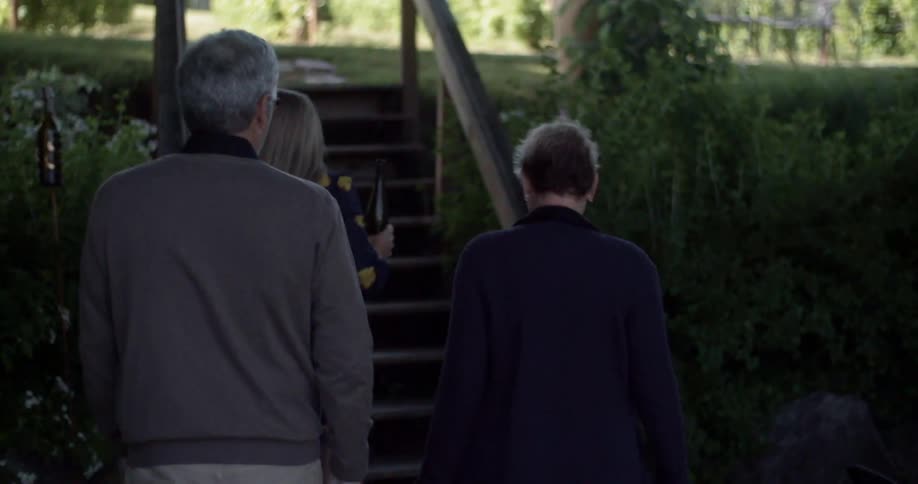Three people walk up a small set of stairs in the day time