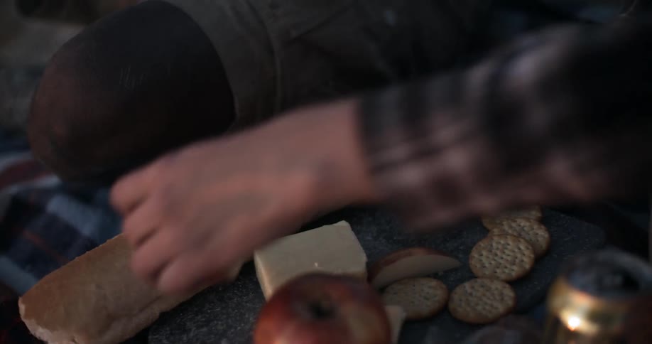 A person is cutting some fruit at picnic