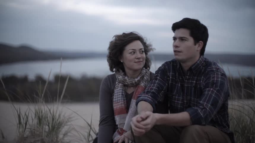 A man and woman sit outside and talk