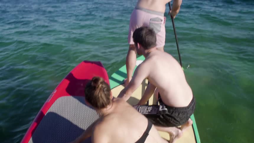 People are on surfboards paddling in the water