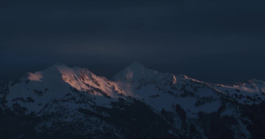 A snow covered mountain range at night
