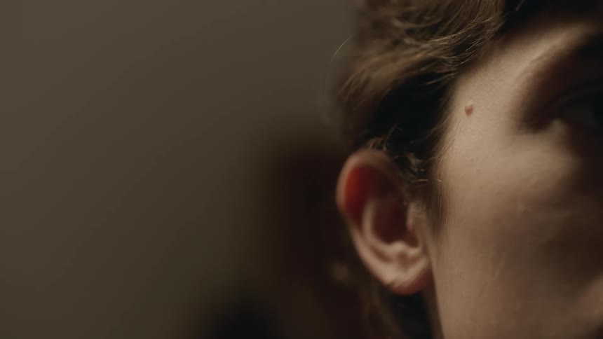 Person with mole near their temple blinks