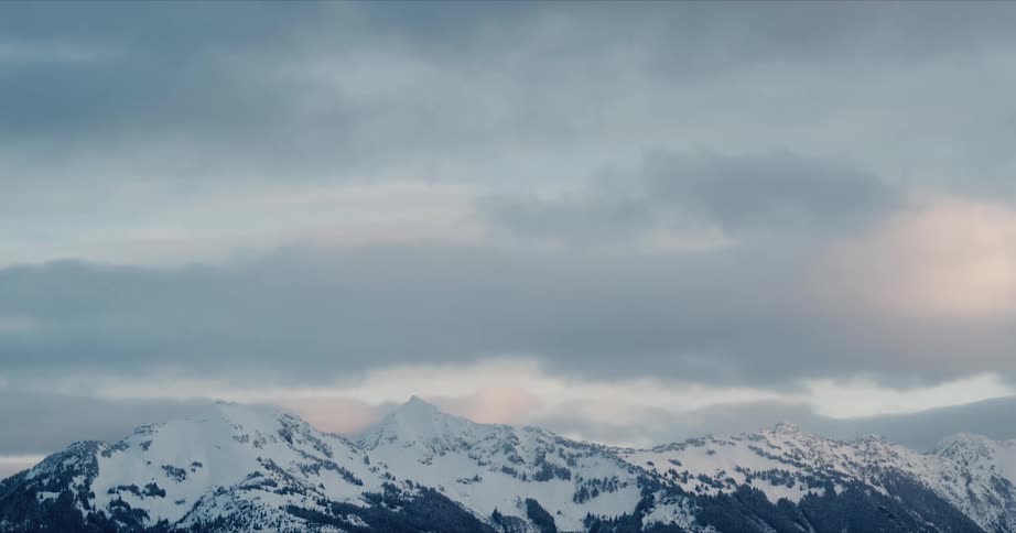 A snow covered mountain range at dusk