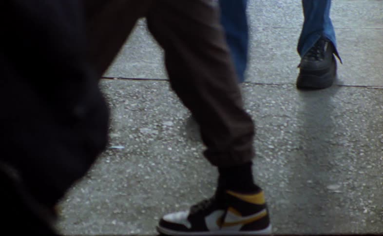 Close up of the legs of people as they walk on a city street