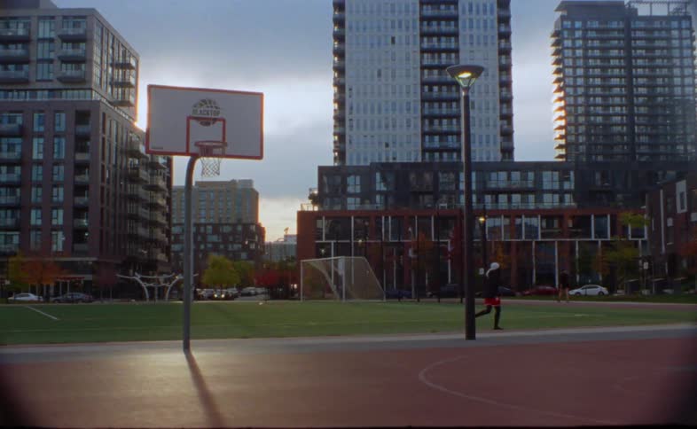 A man runs past a public park in a neighborhood as another person walks past the park
