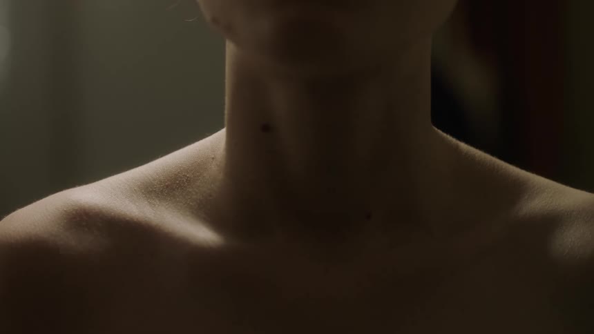 A person stands shirtless in a room