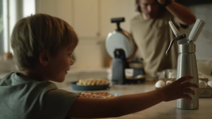 Father prepares waffles and serves them to his family