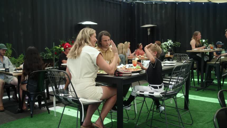 A mother father and son sitting at a table eating