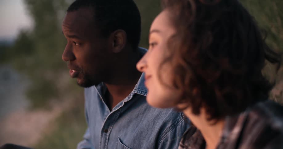 A man and woman talk and laugh outside