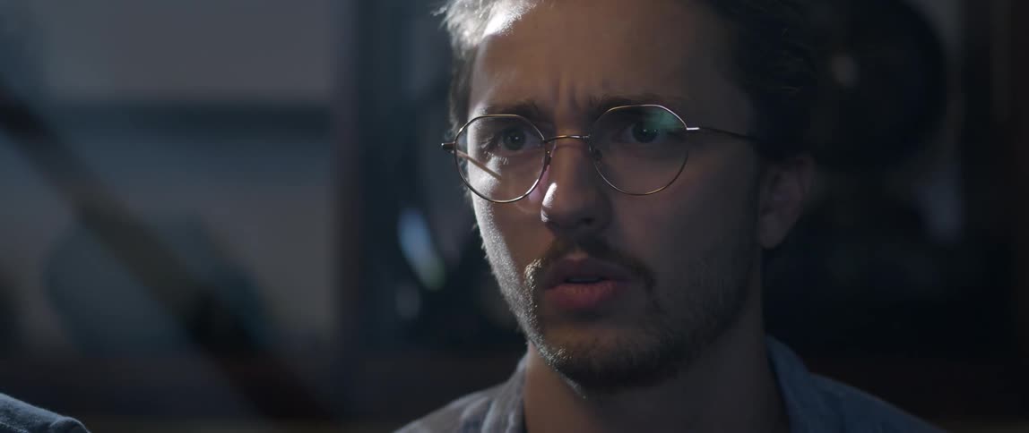 Man with beard and round glasses plays video game talking