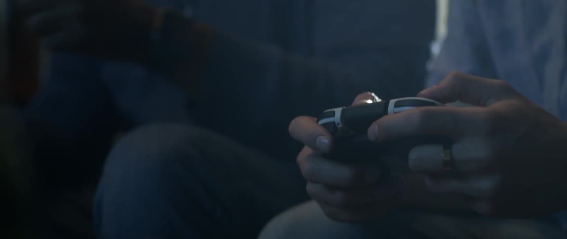 Two men fist bump while playing video games