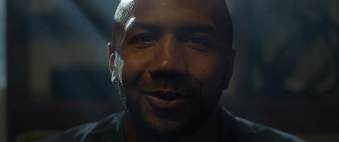 Happy adult man smiles while playing video games in the living room at home