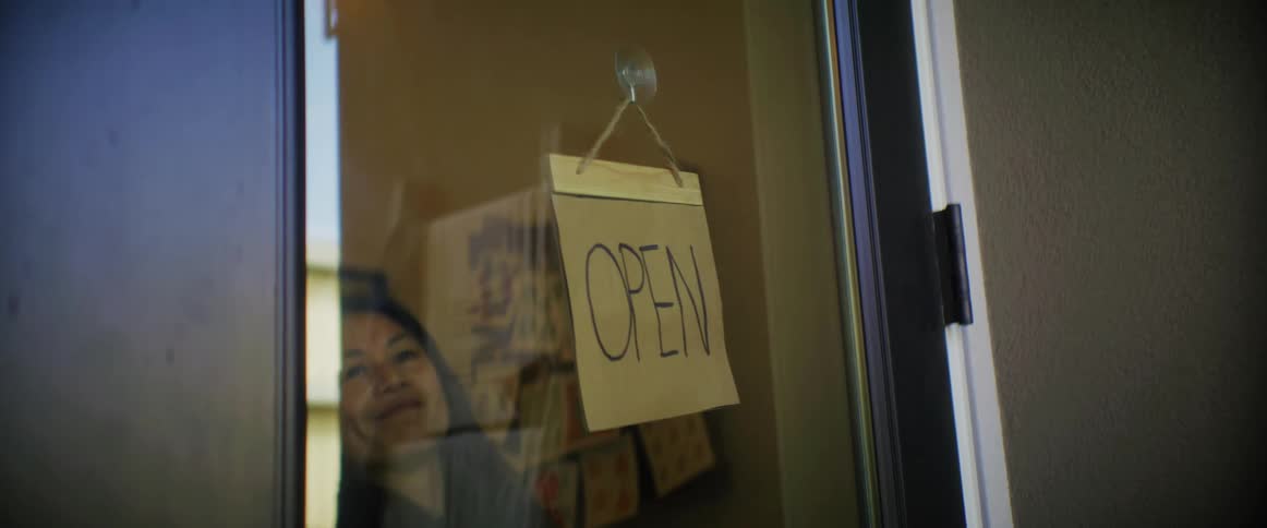 Street store owner turns around the open sign on the entrance door