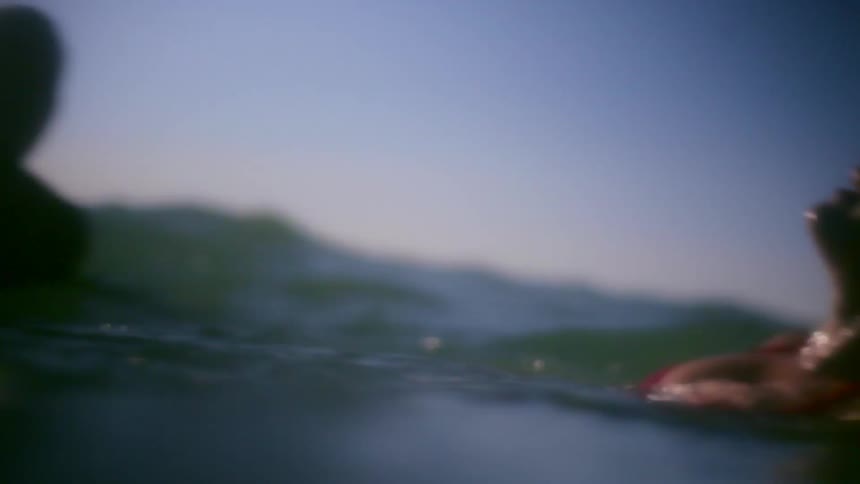A man and woman laughing as they swim in the ocean