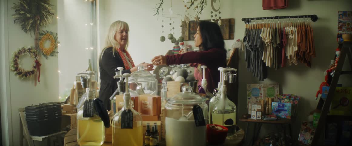 Shopkeeper shows goods to a customer in a small street shop