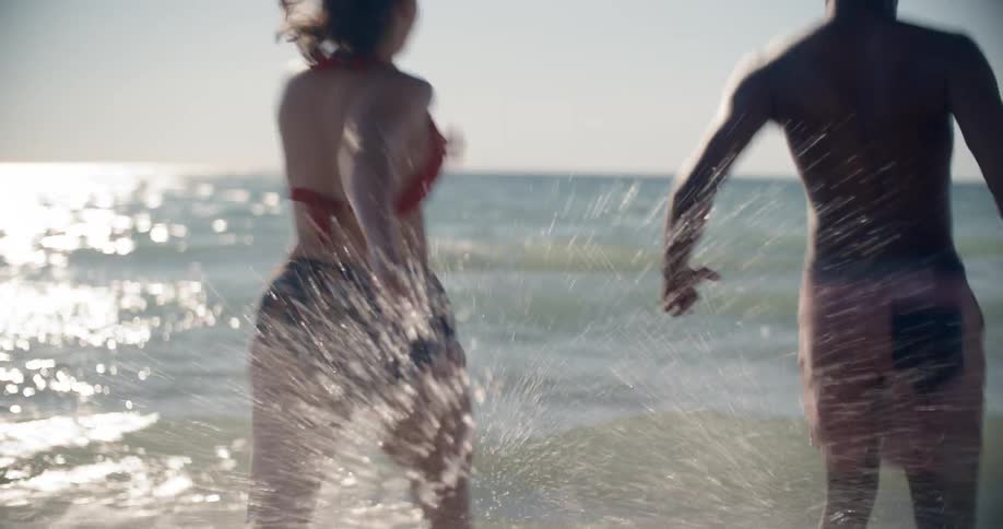 A man and woman race into the water