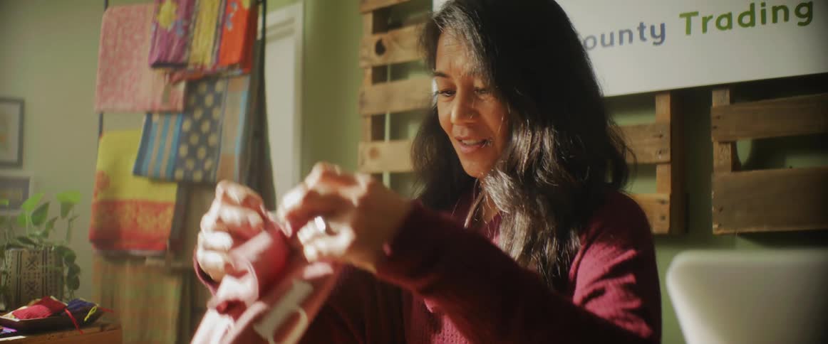 A woman folding clothes in a store