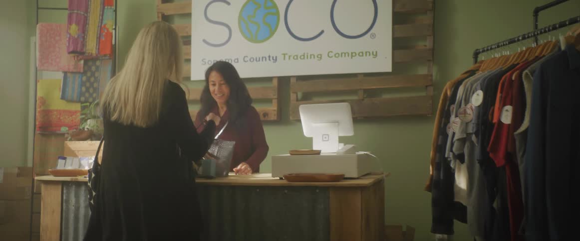 Woman shopping on a clothing store brings a full basket to the cashier