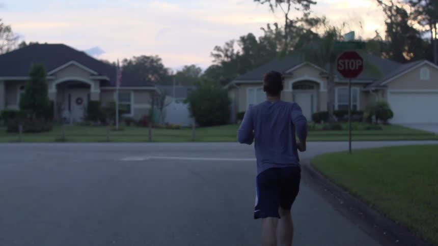 Man jogging down a subdivision road in slow motion