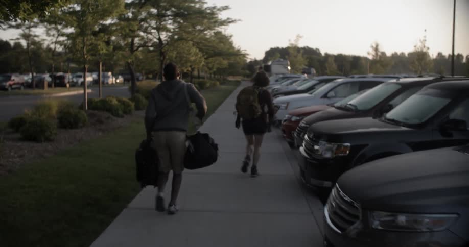 A young man and woman jog down the sidewalk