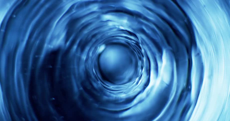 Light reflects on the edges of a blue swirling tunnel vortex as it rapidly spins