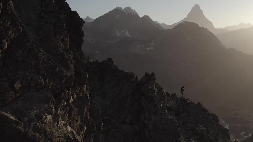 A hiker stands on the side of a steep canyon