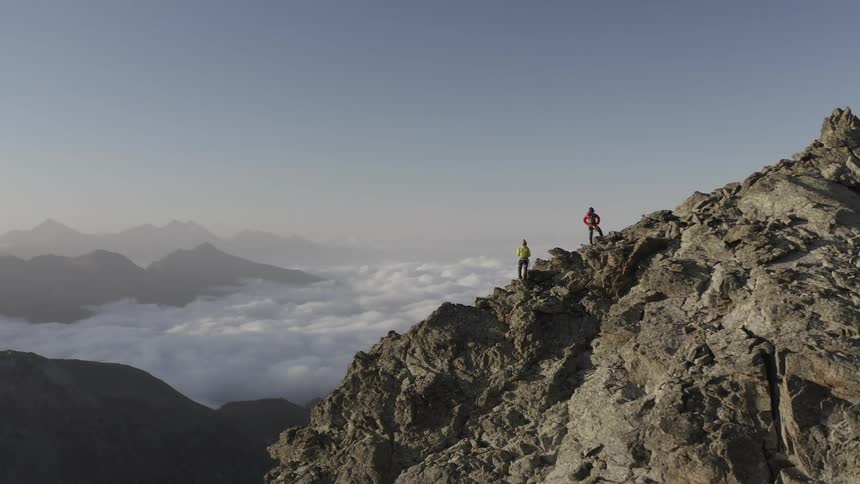 There is two people that are on a mountain and looking at the sky