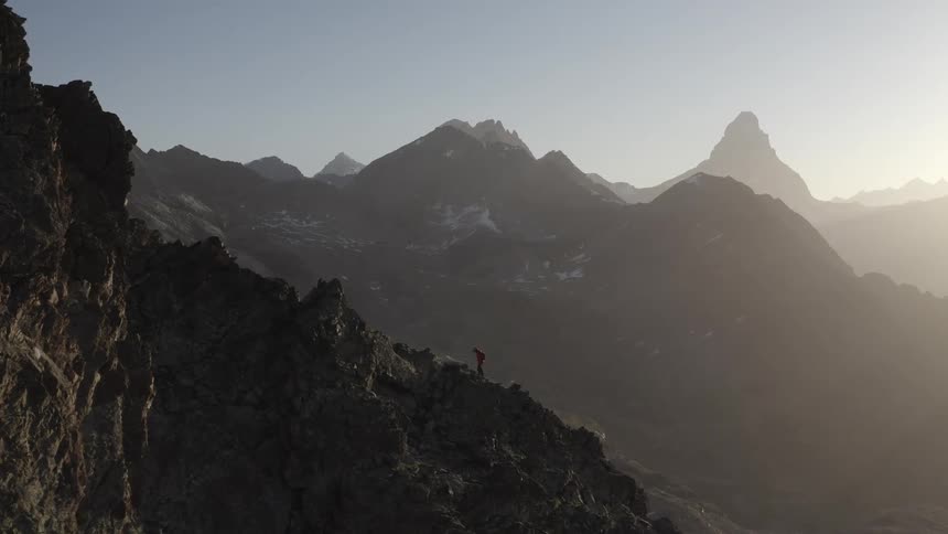 A mountaineer climbs a mountain slope at high altitude on a clear day