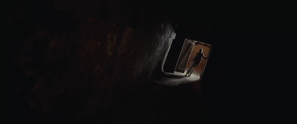 A person exits the dark hallway