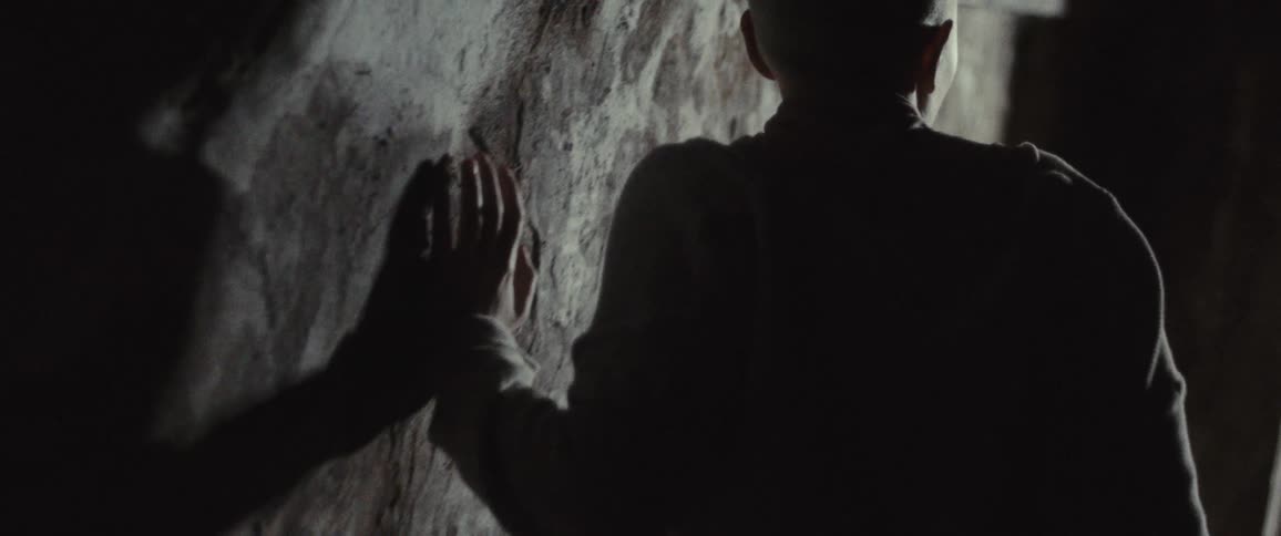 Nervous woman with short hair touches wall