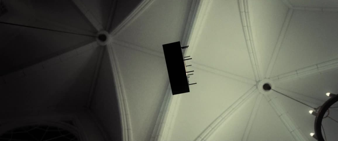 Spiked object flies through the air under white ceiling and chandelier