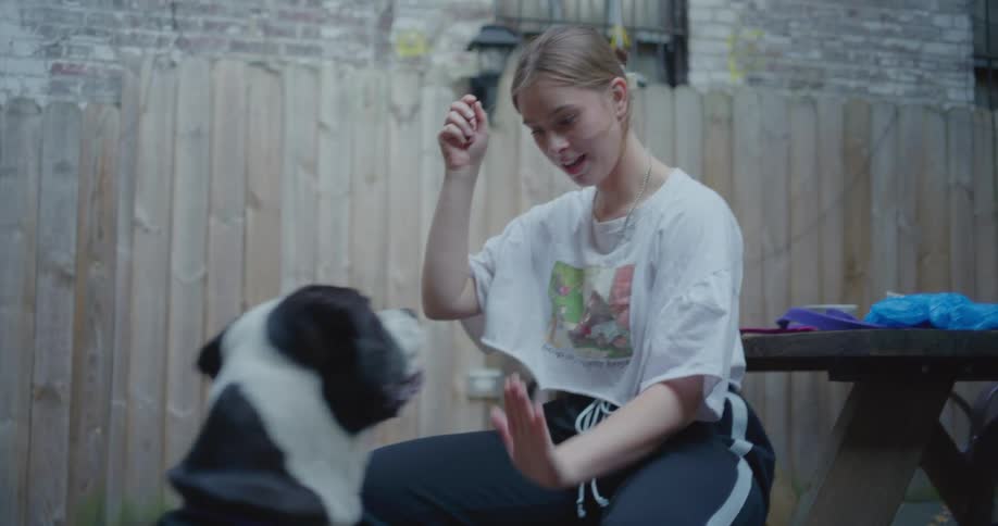 A woman is playing with her dog outside