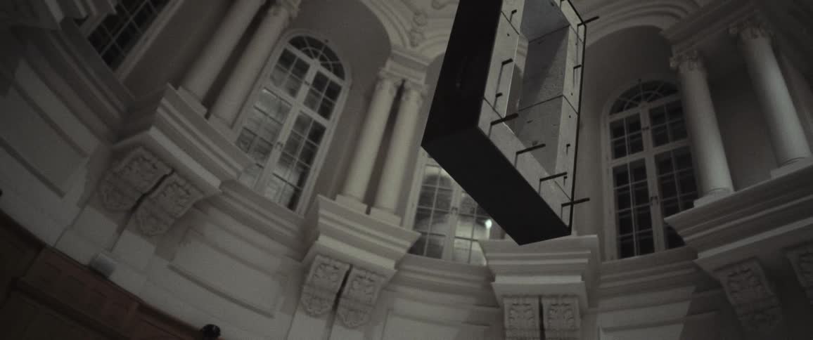 A person standing in a large room with a structure floating above them