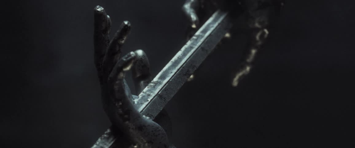 Reveal of a sculpture of two hands with a blade piercing them
