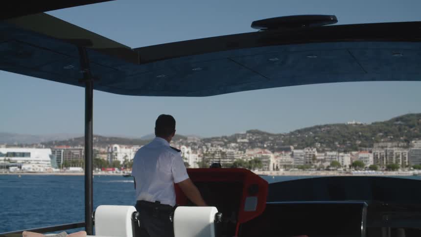 A man is driving a boat on the ocean water