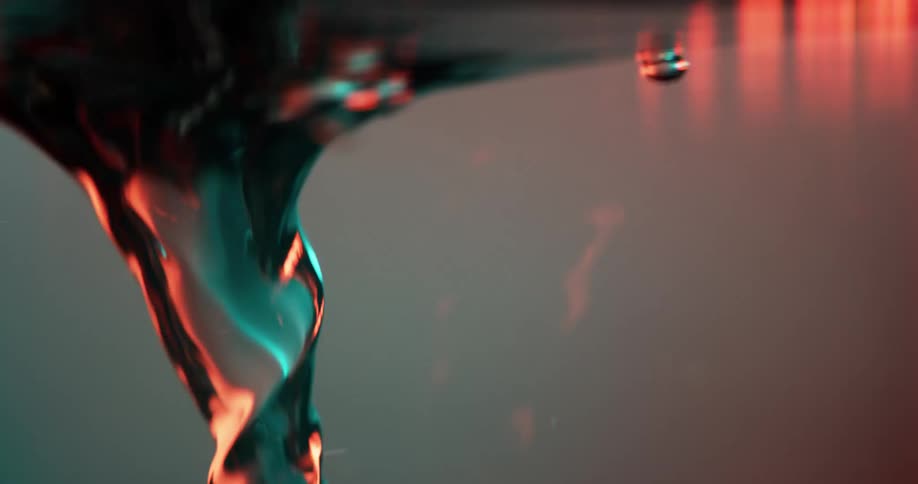 A side view of water in a glass container spinning and creating a whirlpool with swirling bubbles