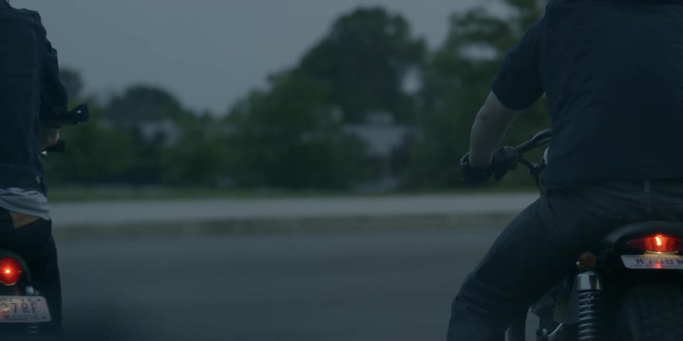 A man sits on his motorcycle as cars pass
