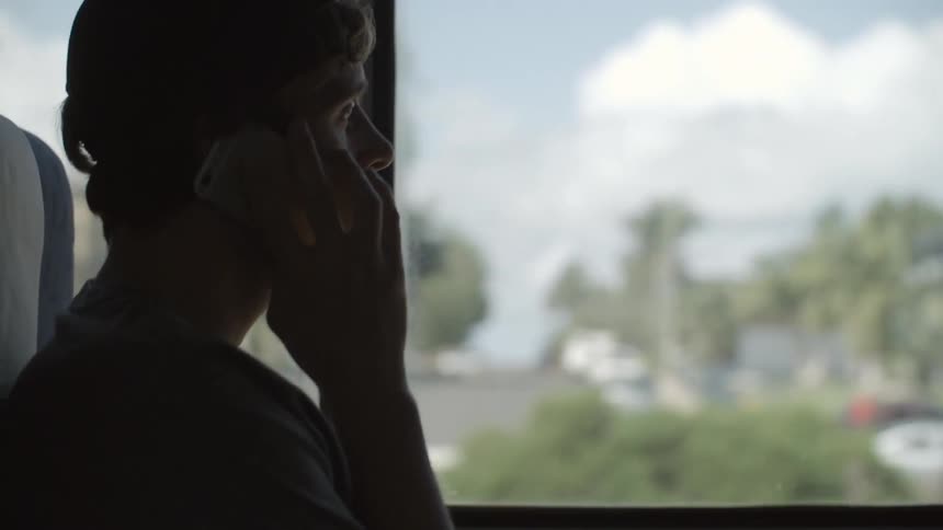 A man riding public transit talking on his cellphone