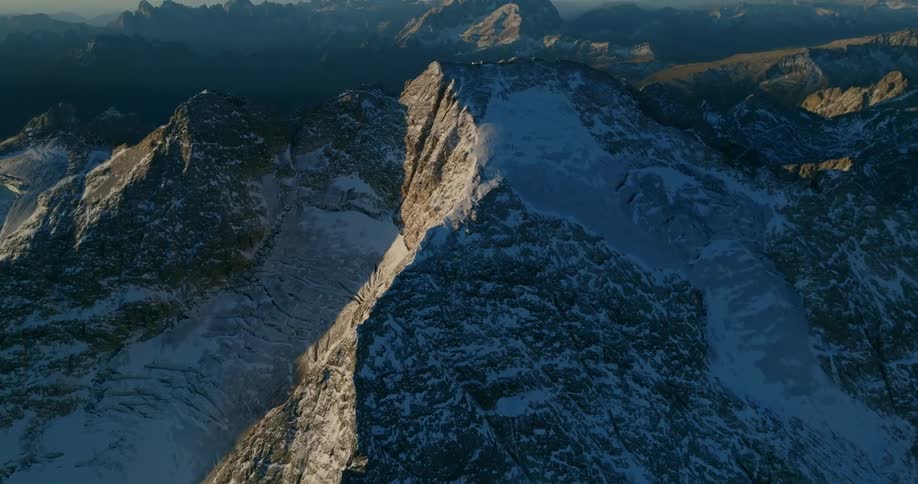 A vast snow littered mountain range during the day
