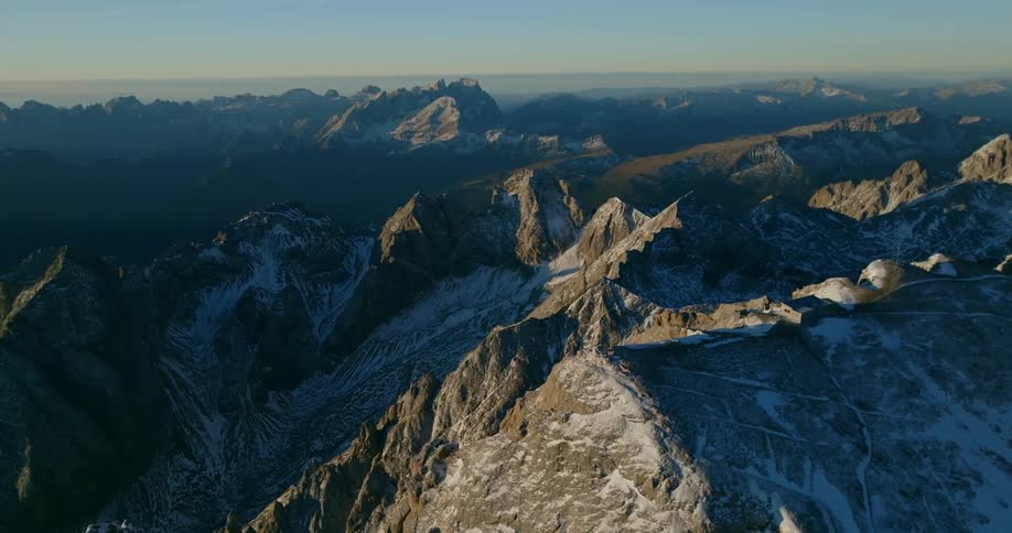 An aerial view of a rocky mountain landscape with ice at dusk